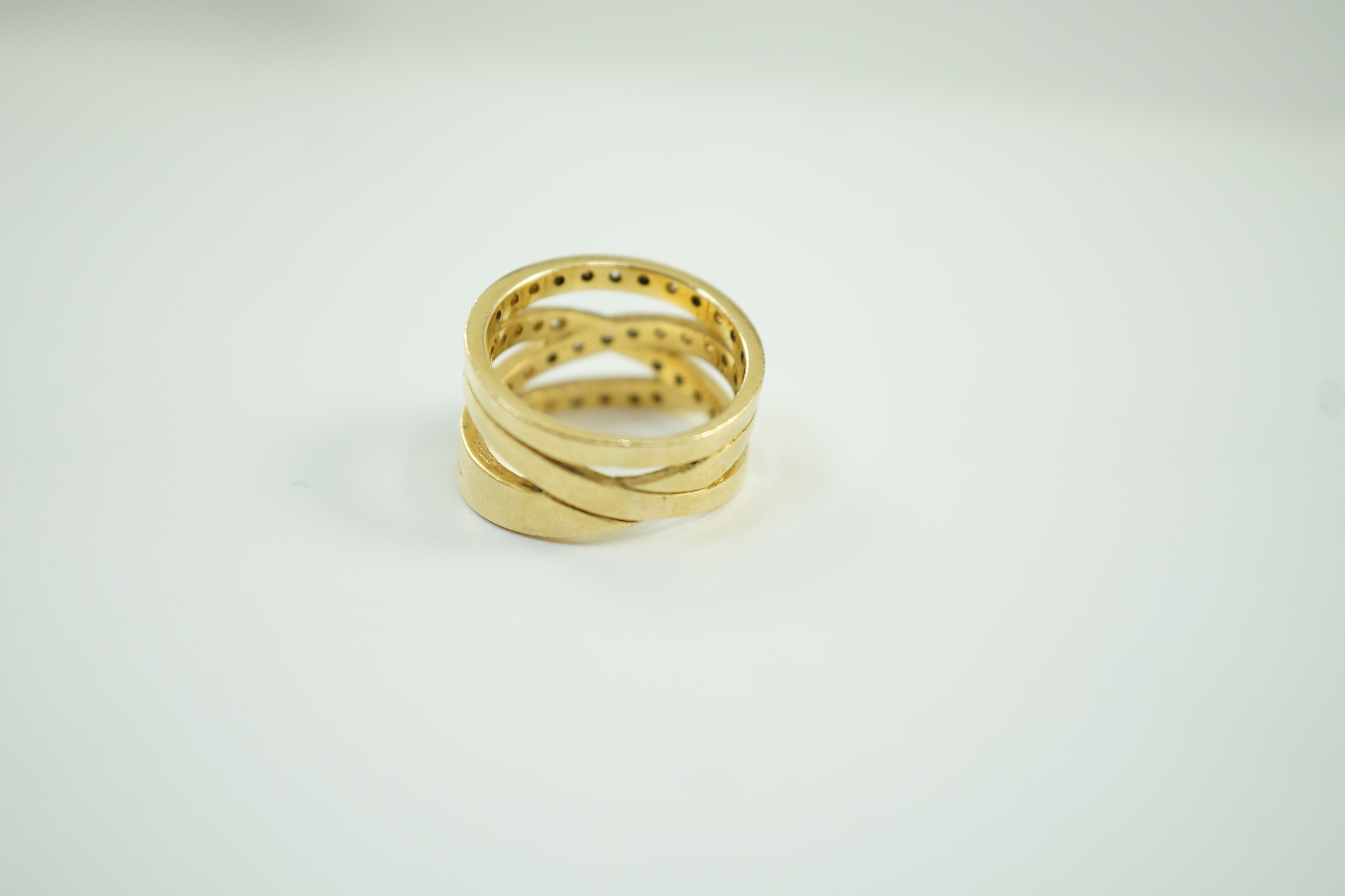 A modern 750 and diamond chip cluster set multi shank dress ring, size P, gross 10.1 grams.